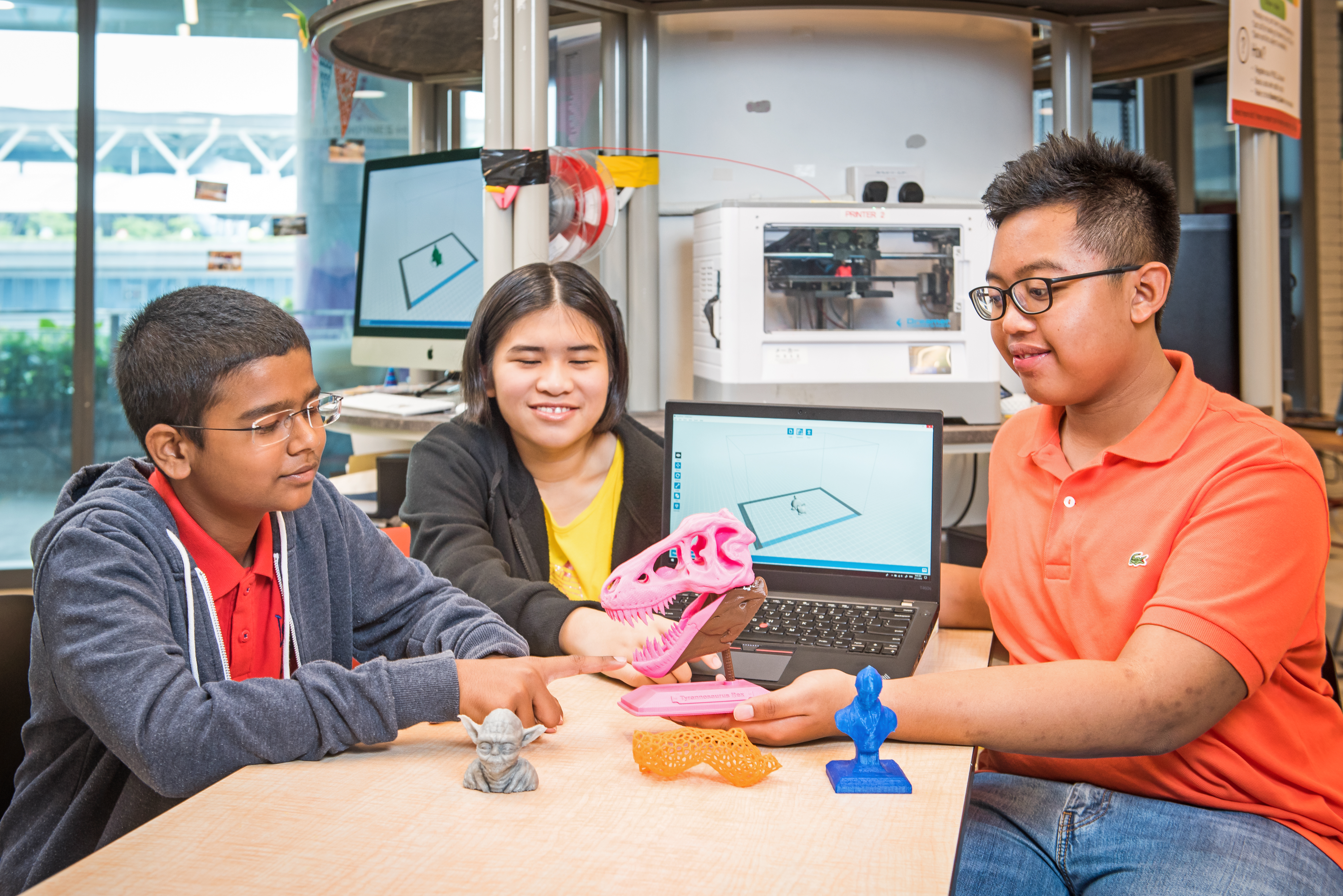 Three Youths displaying 3D printing products
